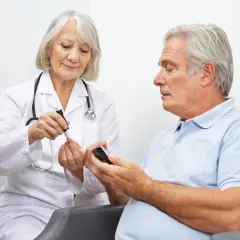 Diabetolog bada poziom cukru we krwi pacjenta.