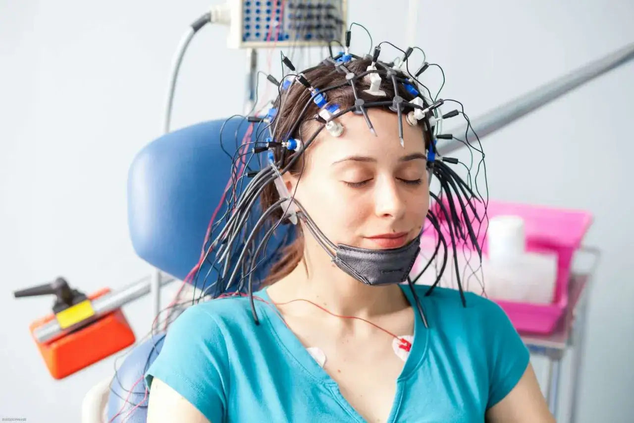 Kobieta z elektrodami na głowie podczas badania eeg.